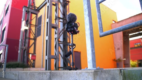 A steadycam with a Camera / DSLM  setup with microphone mounted on it. photo