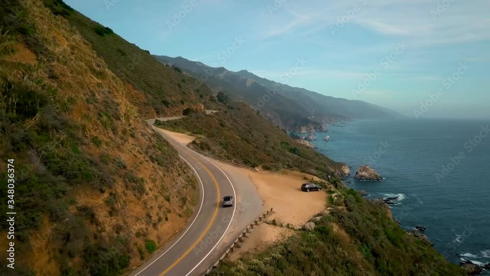 Car drives next to cliff around bend on California Big Sur coastline Car drives next to cliff around bend on California Big Sur coastline