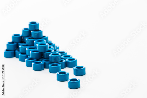 Closeup of Stack of Ferrite Magnetic Cores of Blue Color Placed in Batch. Isolated On White. Focus on First Item