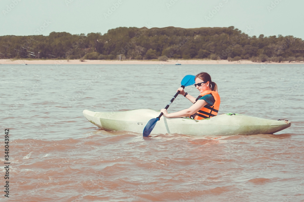 Naklejka premium Athletic girl is kayaking.