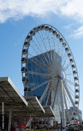 A white wheel of fortune in front of the blue sky with a few clouds