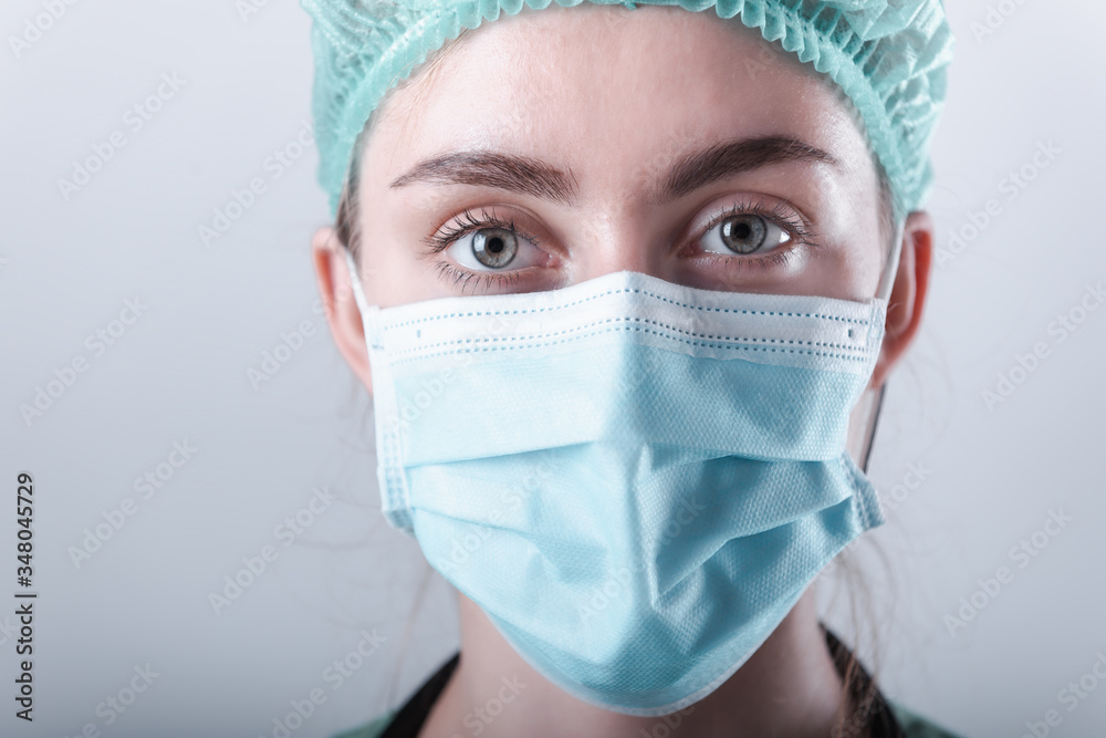 Female Doctor in Protective Mask and Medical Cap on Isolated Background, Closeup Portrait of Medicine Surgeon Doctor Wearing Medical Mask With Copy Space. Clinical Health Care/Doctors Occupation Female Doctor in Protective Mask and Medical Cap on Isolated Background, Closeup Portrait of Medicine Surgeon Doctor Wearing Medical Mask With Copy Space. Clinical Health Care/Doctors Occupation
