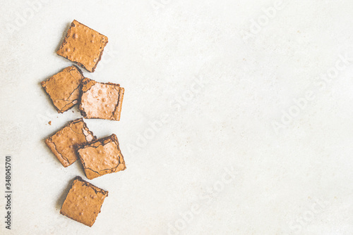 Obraz na płótnie Top view of freshly baked home made brownie cake cut in squares over white rustic background. Copy space. w salonie