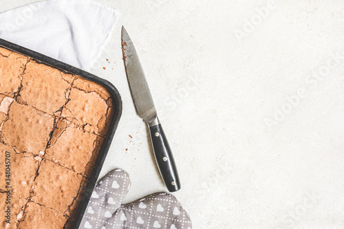 Obraz na płótnie Top view of freshly baked home made brownie cake cut in squares over white rustic background. Copy space. w salonie