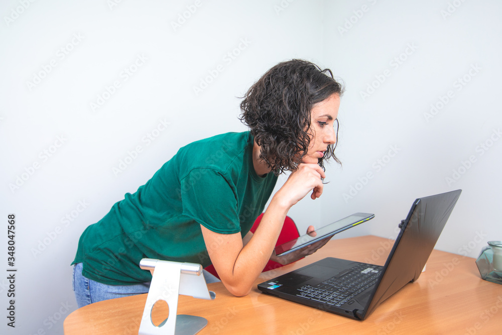 pensive young girl, looking at her laptop, home office pensive young girl, looking at her laptop, home office