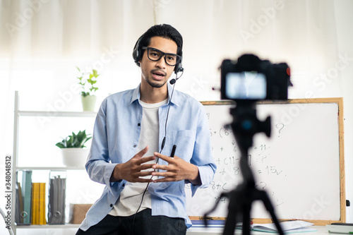 Asian school male teacher working from home teaching online math subject to student studying from home. Man using camera to record his live on internet. Remote education class during covid19 pandemic.