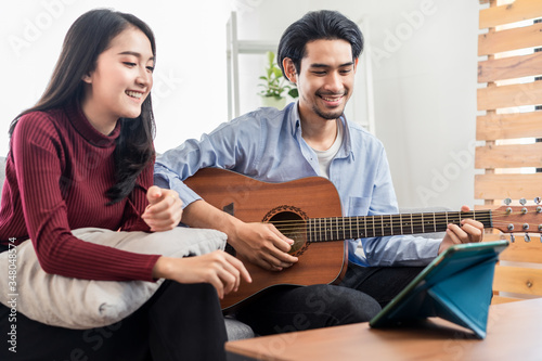Couple vlog influencer performancing music and girl singing show to streaming internet online audience listening at home. Man playing guitar and woman sing a song. Home entertainer and blogger concept