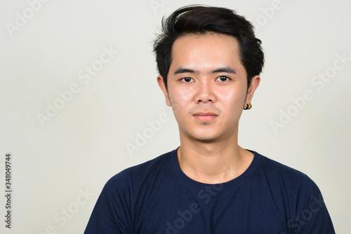 Portrait of young Asian man looking at camera