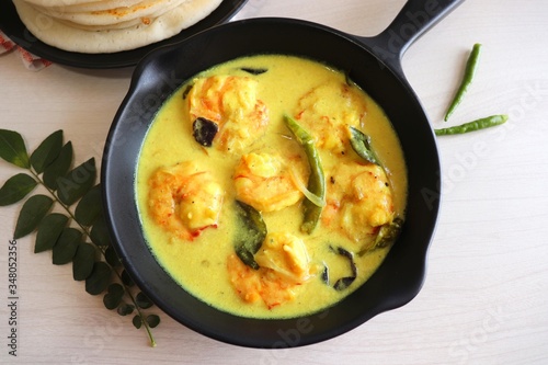 Yellow Prawns or Shrimp curry served with Amboli or Soft Dosa. Prawns cooked in coconut milk with mild spices. Prawns yellow Thai Curry. Goan fish Curry. Ingredients background with copy space. 