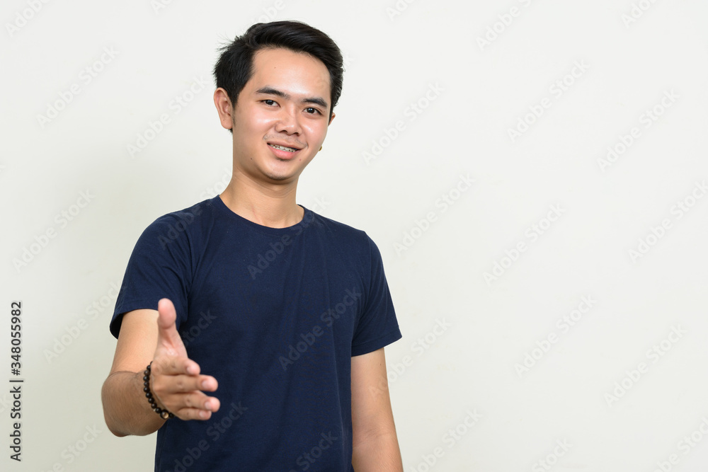 Portrait of happy young Asian man giving handshake Portrait of happy young Asian man giving handshake