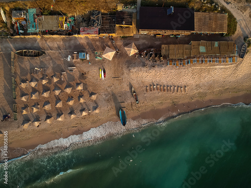 Aerial view of amazing beach with umbrellas and turquoise sea at sunrise. Black Sea at Vama Veche, Romania photo