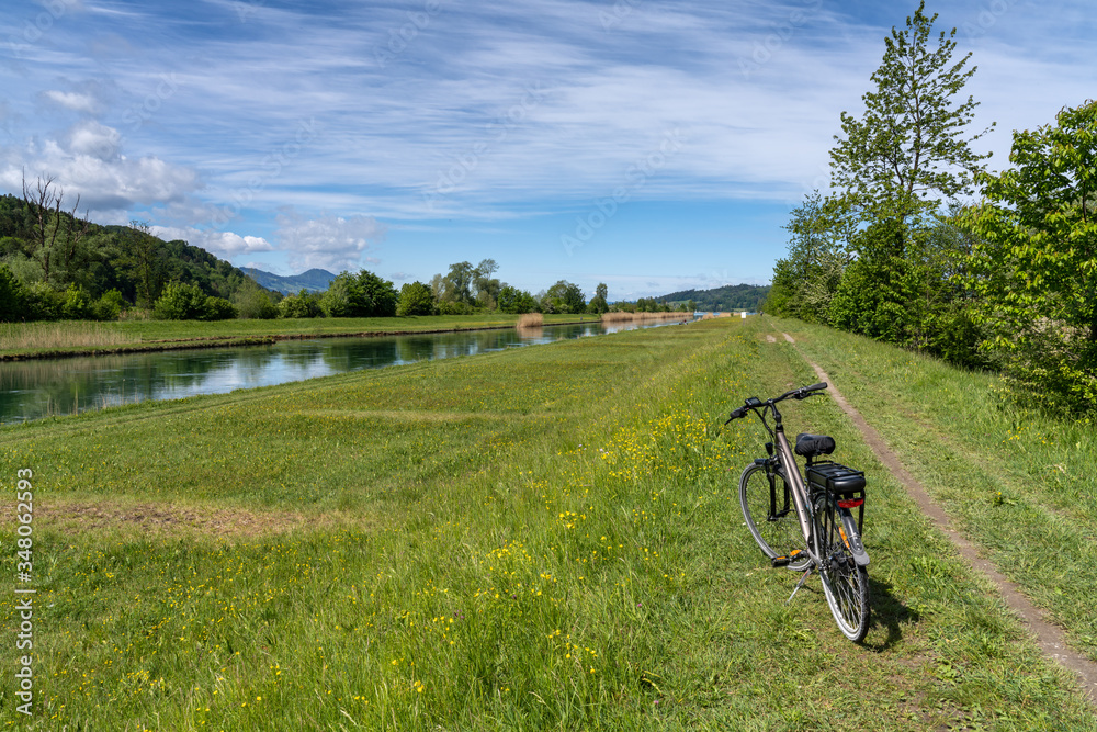 Obraz premium Biking along the mouth of Linth river and canal at the head of the Upper Zurich Lake (Obersee), St. Gallen, Switzerland