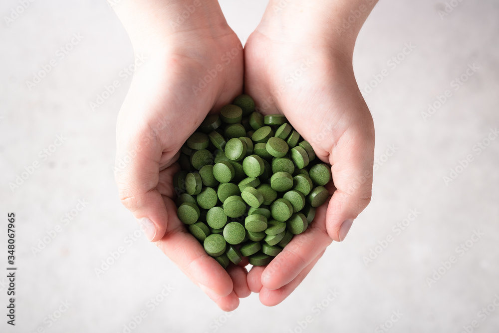Chlorella pills in hand . Concept of superfood and detox. Chlorella pills in hand . Concept of superfood and detox.