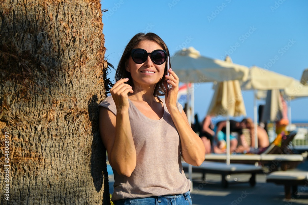 Portrait of smiling woman relaxing in resort hotel using smartphone Portrait of smiling woman relaxing in resort hotel using smartphone