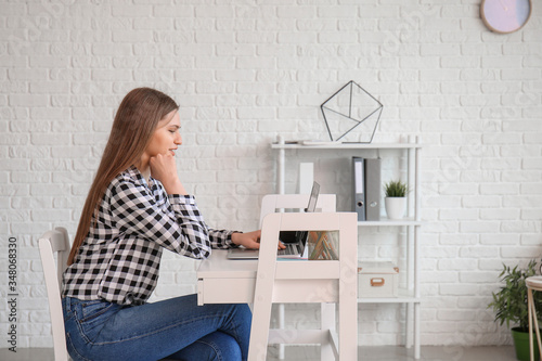 Young woman with laptop wor...
