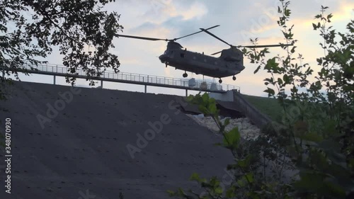 RAF Chinook helicopter deployed to repair a damaged dam, dropping sandbags
 photo