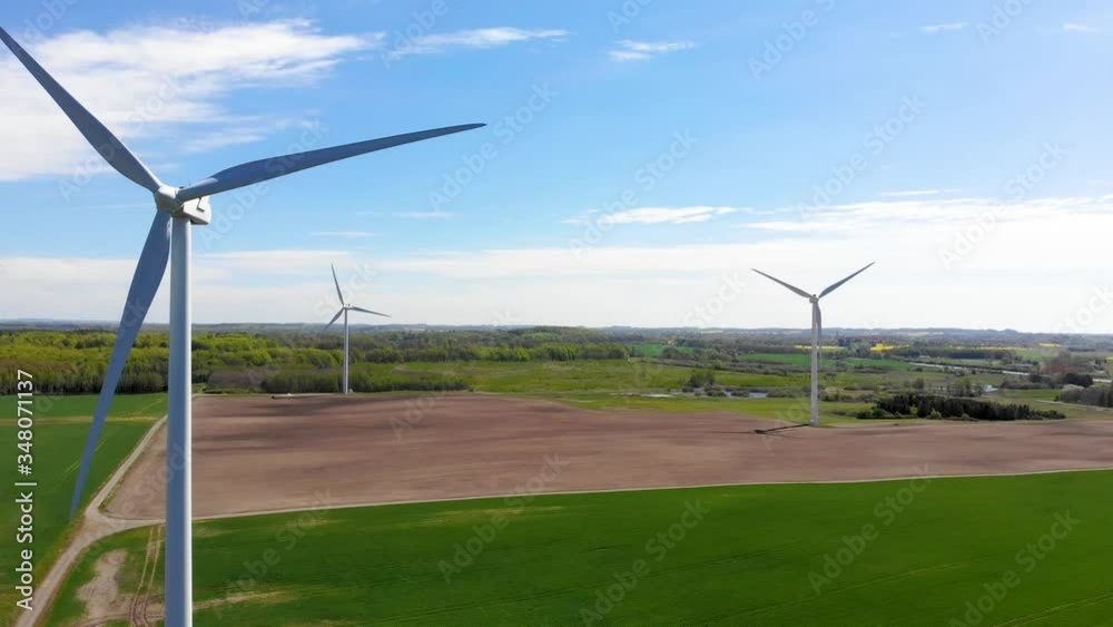 Drone flying sideways getting nice view of three spinning windmills Drone flying sideways getting nice view of three spinning windmills