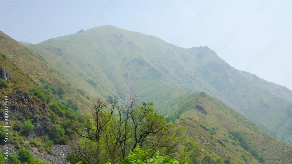 Naklejka premium mountain landscape road high mountains with haze and clouds