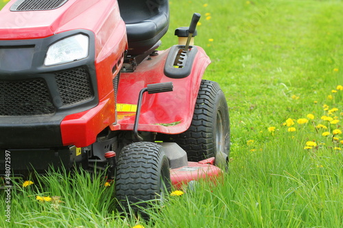 Mowing or cutting the long grass with a lawn mower . Gardening concept background