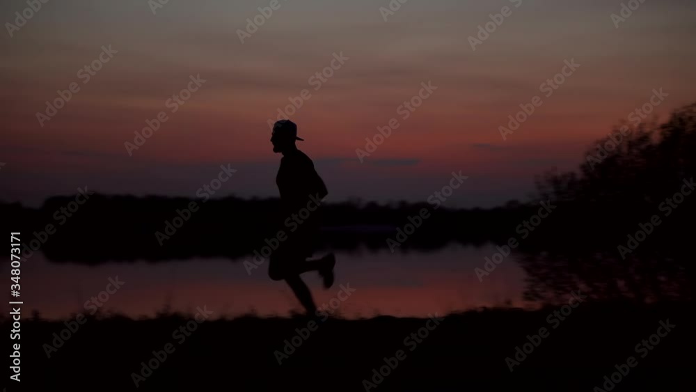 Runner Training In Sunset . Endurance Running Silhouette Exercise At Sunrise. Workout Jogger Exercise Before Run Runner Training In Sunset . Endurance Running Silhouette Exercise At Sunrise. Workout Jogger Exercise Before Run
