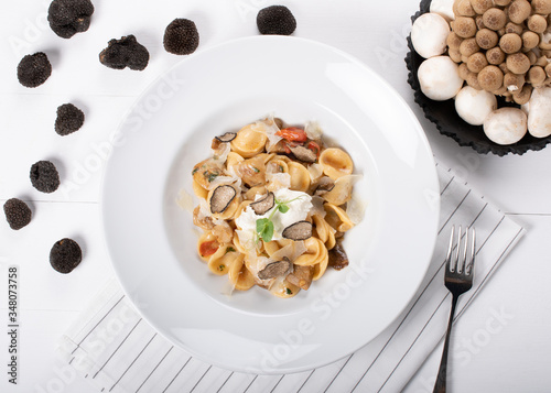 Orecchiette pasta with ceps, cherry tomatoes, ricotta gratin, fresh truffles and wild mushrooms photo