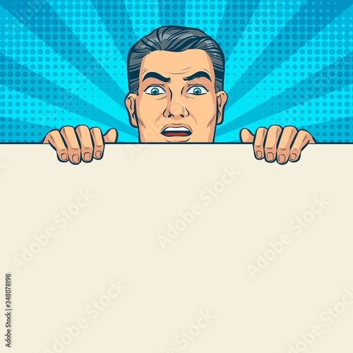 Surprised man looking over a white wall. Pop art vector illustration