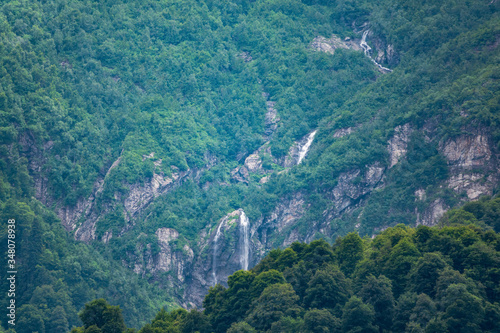 Green mountains with a high waterfall in spring or summer