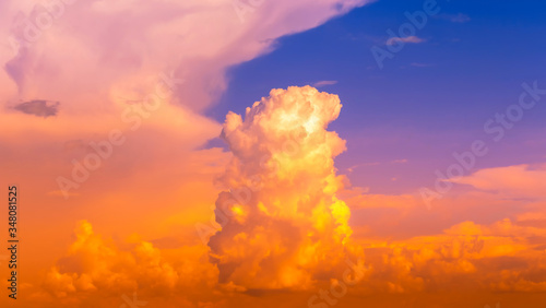 Fire clouds tower with hot orange sunset light in sky