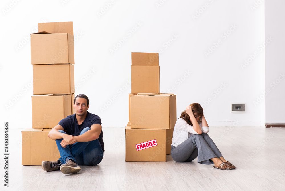 Young pair and many boxes in divorce settlement concept Young pair and many boxes in divorce settlement concept