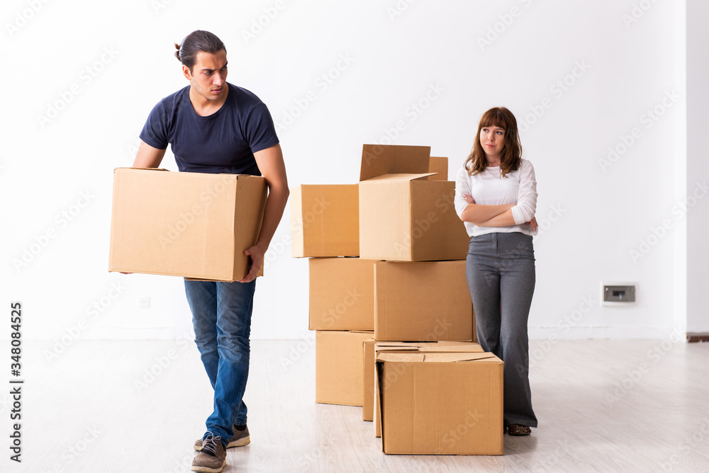 Young pair and many boxes in divorce settlement concept Young pair and many boxes in divorce settlement concept