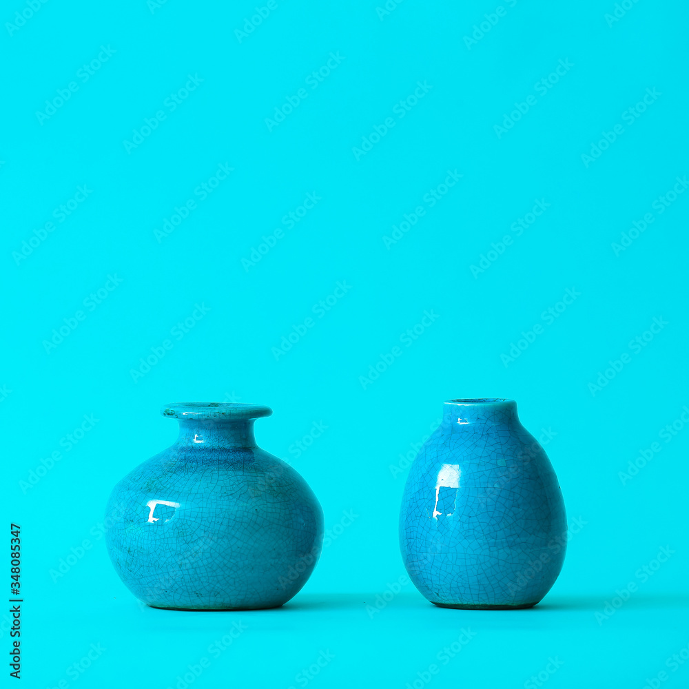 Different vases on color background