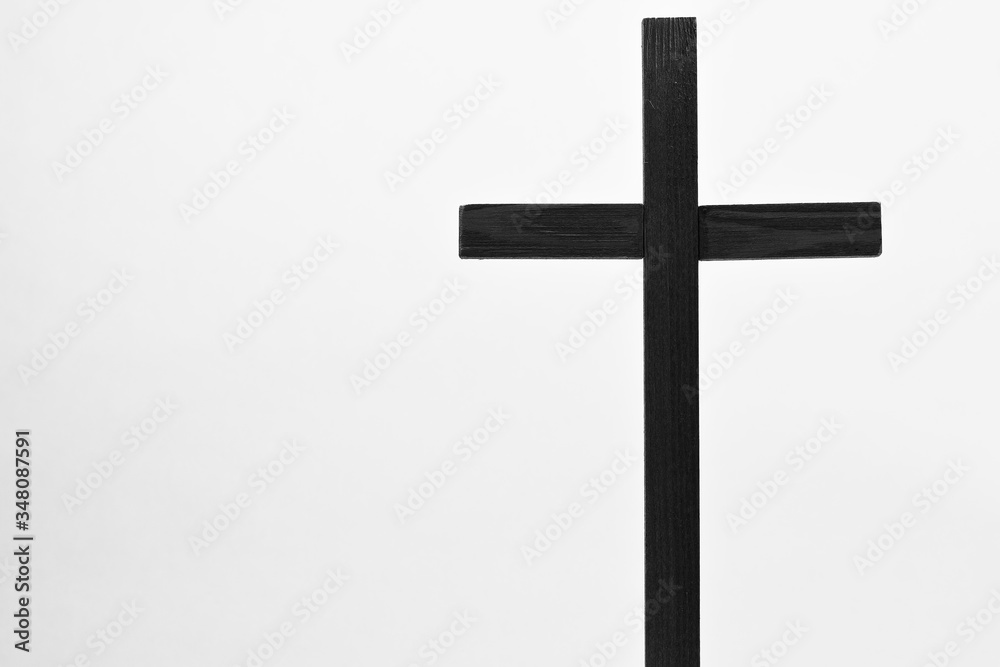 Crucifix is a monochrome isolated image of a dark holy cross with a white background. The crucifix is a sacred religious symbol.