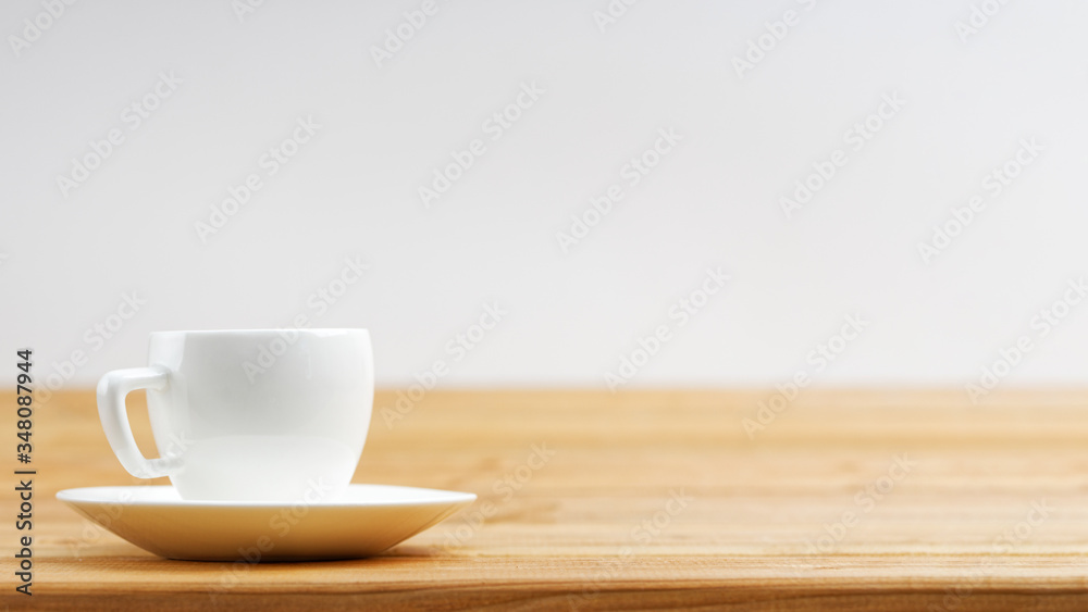 White cup of coffee espresso on wooden background. Shallow focus. Front view with copyspace.