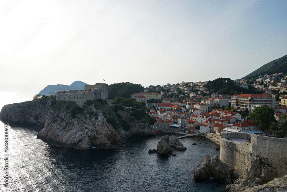 Exterior architecture and design of Dubrovnik old town city walls and landscape with clear blue sky, southern Croatia fronting the Adriatic sea encircled with massive stone
