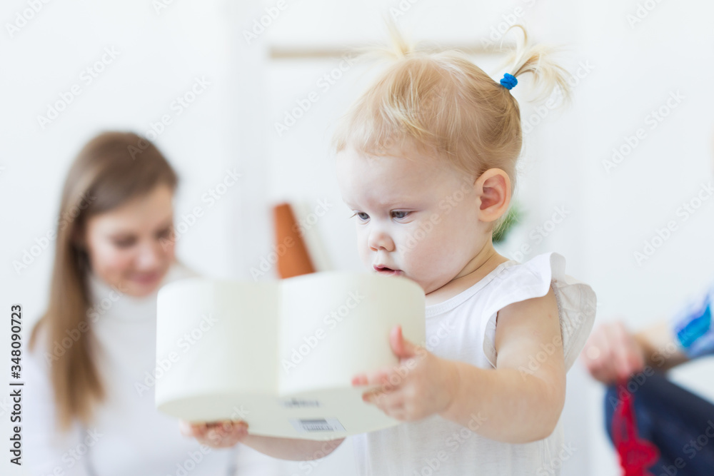 Funny baby toddler girl playing in living room. Children and family concept. Funny baby toddler girl playing in living room. Children and family concept.