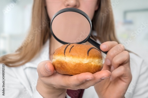 Scientist examines a doughnut with magnifying glass
