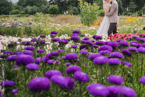 bride and groom in a park with flowers