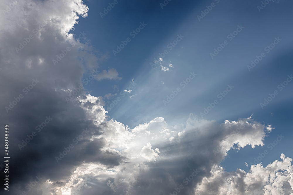 Obraz premium Besutiful ray of sunlight breaking through clouds at sunset.