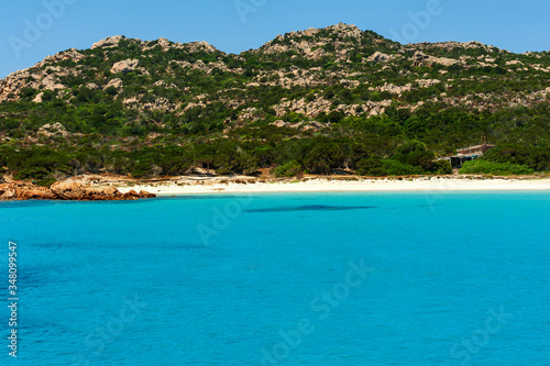 A view from a yacht of the crystal clear and colorful sea of ​​Budelli island with its famous and protected pink beach on a sunny day, in Budelli island Sardinia Italy 