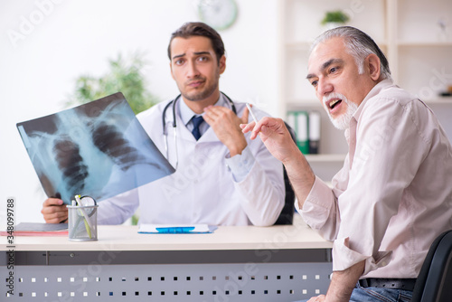 Принти на полотні Young male doctor and old patient in antismoking concept