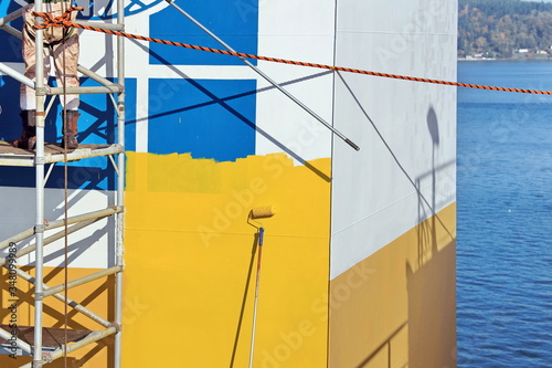 Fotografie Repainting the ship’s funnel and drawing the logo of the shipowner with members of the ship’s crew