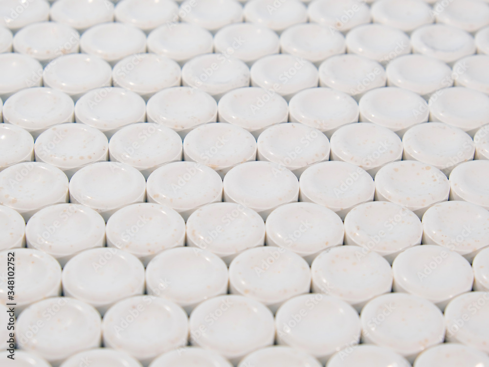 Group of white round pills on a blue background. Textured background. Group of white round pills on a blue background. Textured background.