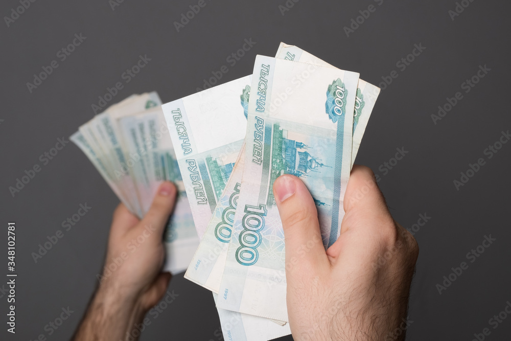 Male hand holds money. Man holds Russian rubles. Russian money, large banknotes in a hand. Male hand holds money. Man holds Russian rubles. Russian money, large banknotes in a hand.