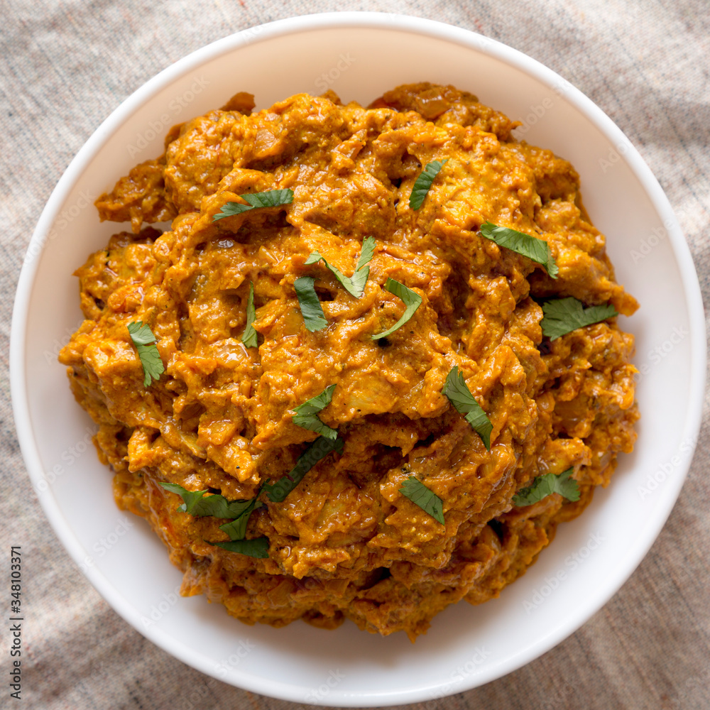 Homemade Chicken Tikka Masala in a white bowl on cloth, top view. Flat lay, overhead, from above. Close-up. Homemade Chicken Tikka Masala in a white bowl on cloth, top view. Flat lay, overhead, from above. Close-up.