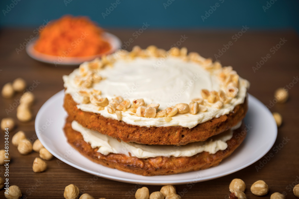 Carrot cake, hazel nuts and grated carrot on the wooden table Carrot cake, hazel nuts and grated carrot on the wooden table
