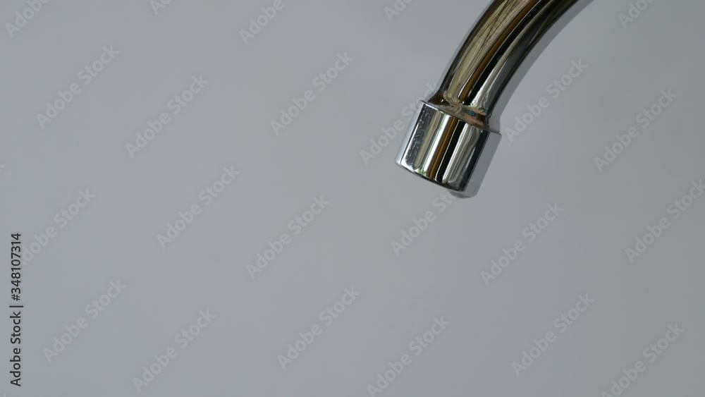 water droplets dripping down from a tap into a sink in the kitchen interior water droplets dripping down from a tap into a sink in the kitchen interior