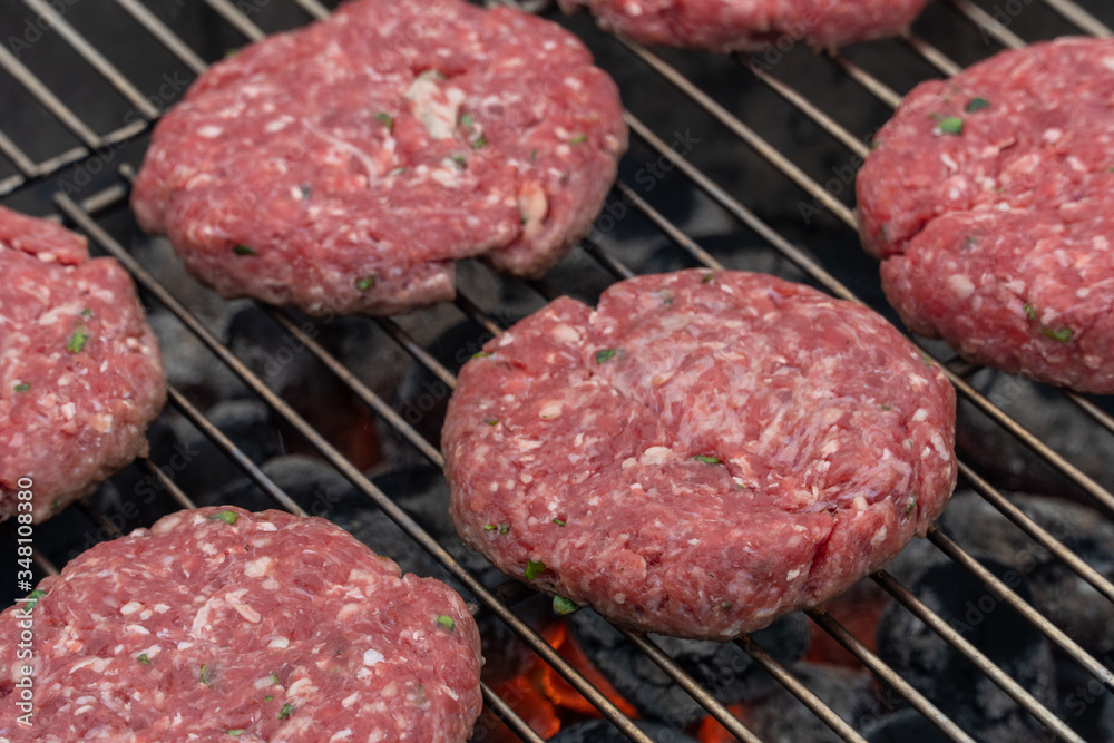 Beef or pork meat barbecue burgers for hamburger prepared grilled on bbq smoke grill, close up