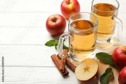 Composition with cider  cinnamon and apples on white wooden background