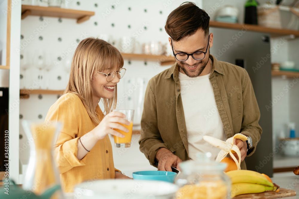 Young couple cooking together at home. Loving couple having fun while cooking. Young couple cooking together at home. Loving couple having fun while cooking.