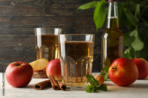 Composition with cider, cinnamon and apples on wooden background